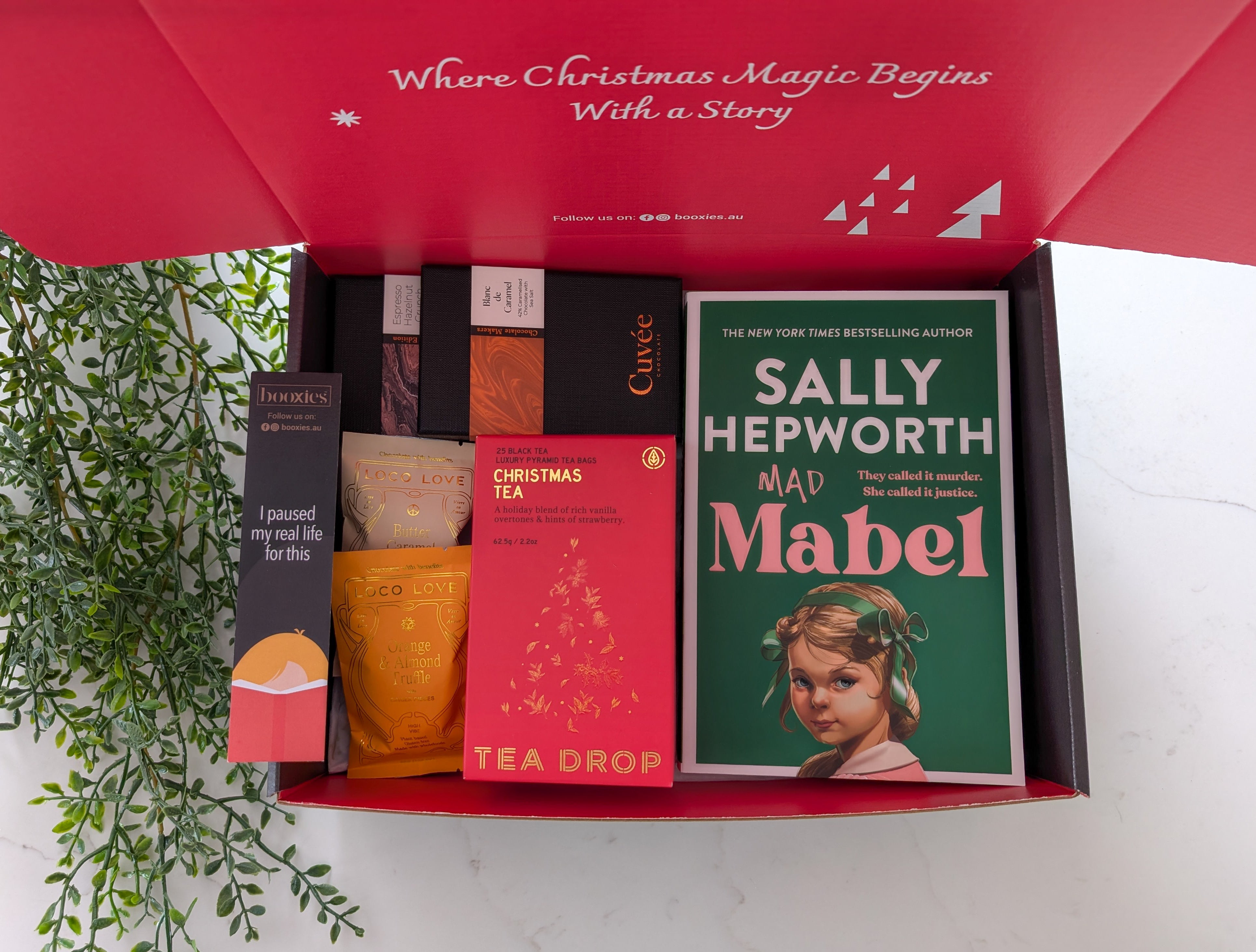 Gift set with books and tea packages, featuring a red box with 'Sally Hepworth' book inside.