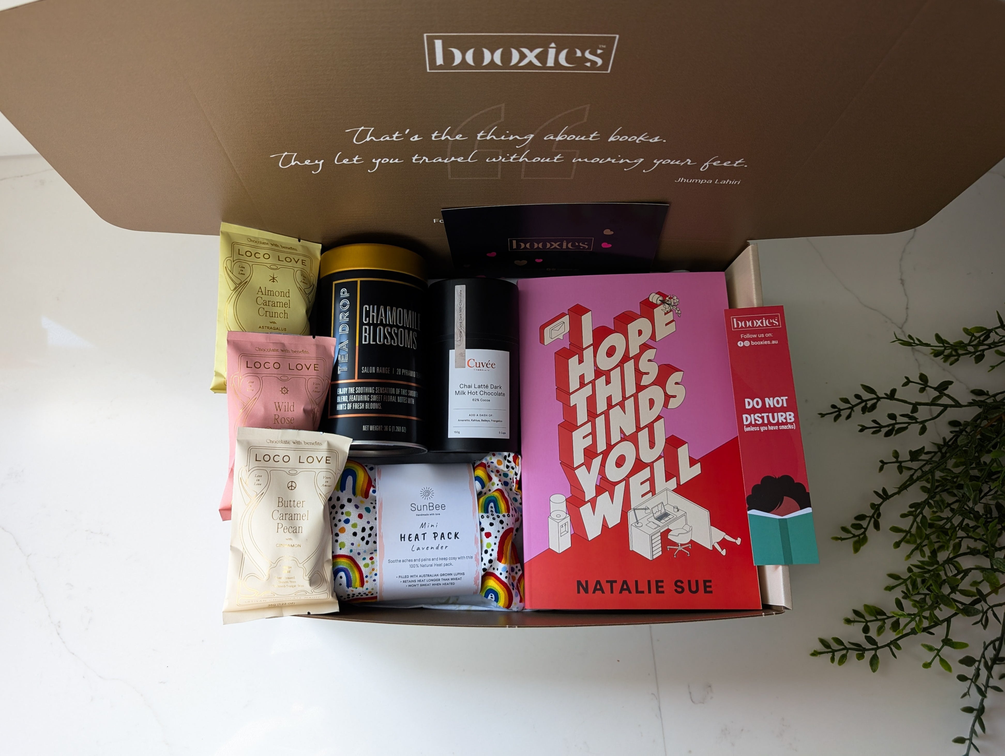 a warm hug booxies gift box including a book from your favourite genre, tea, hot chocolate or chai hot chocolcate, 3x vegan organic chocolate, lavendar heat pack, a bookmark and greeting card