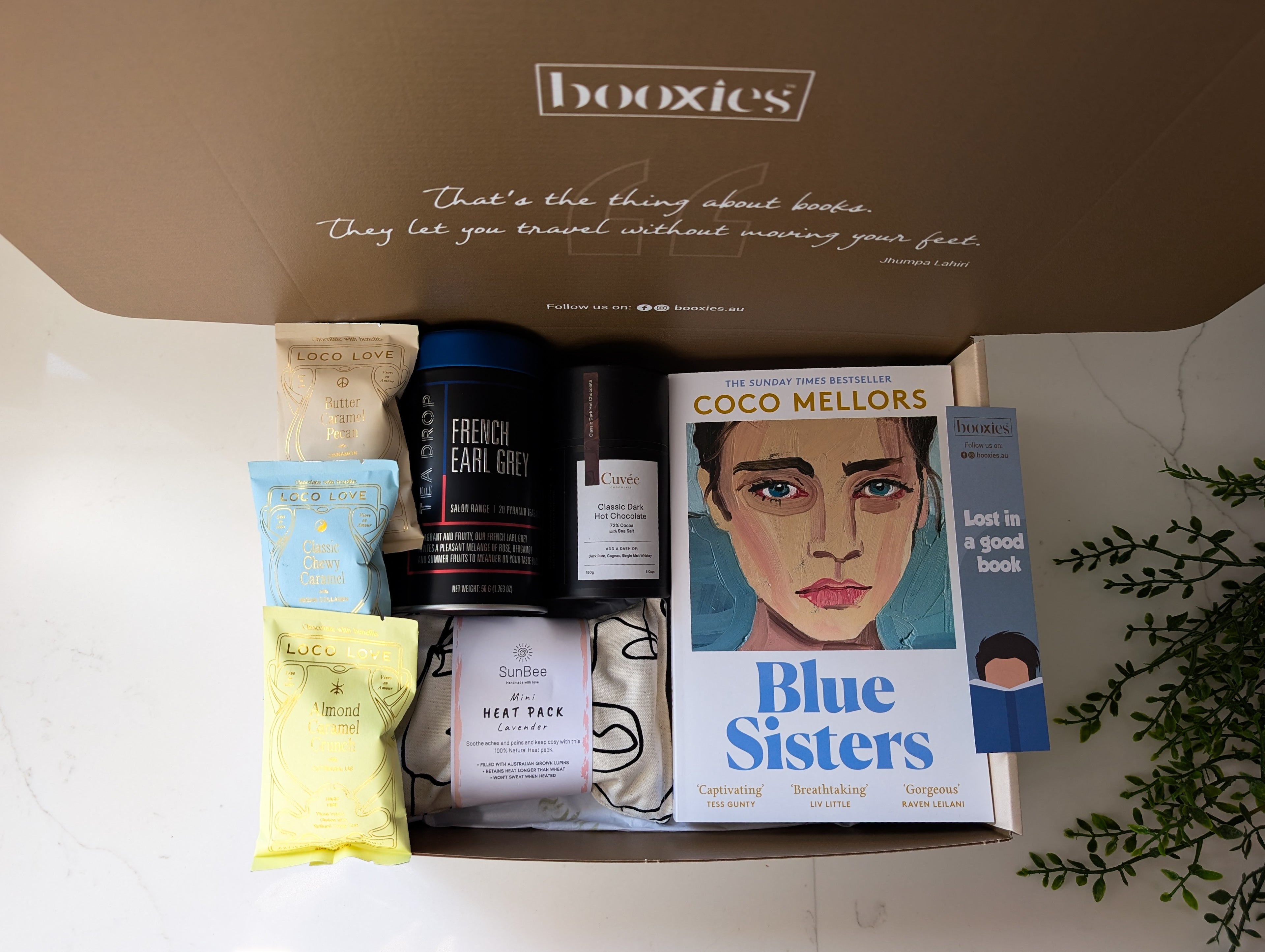 a warm hug booxies gift box including a book from your favourite genre, tea, hot chocolate or chai hot chocolcate, 3x vegan organic chocolate, lavendar heat pack, a bookmark and greeting card