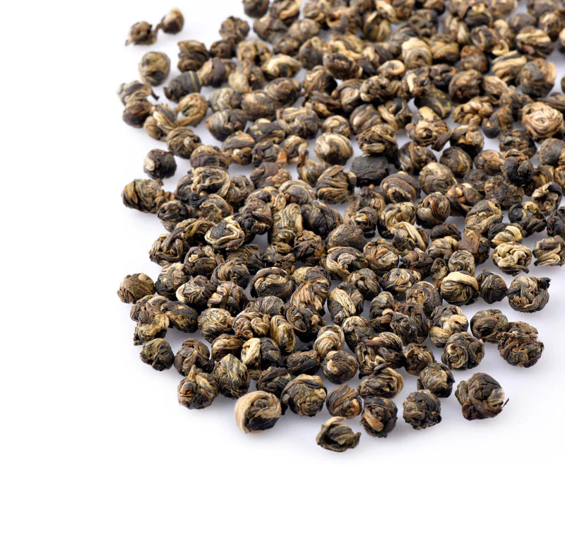 Pile of dried tea leaves on a white background